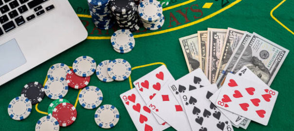 poker chips with banknotes placed on a laptop keyboard. Poker concept