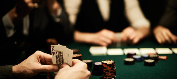 Hands of card player holding king of hearts
