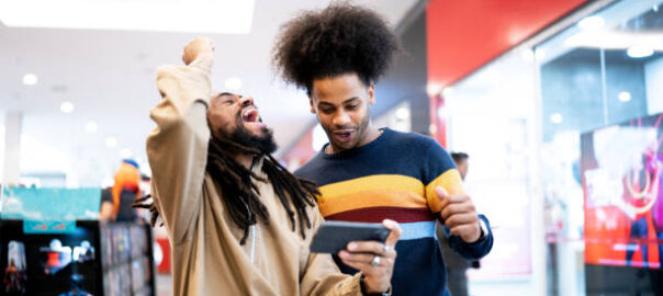 Brothers watching sports or playing on the smartphone at the mall